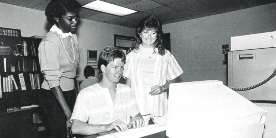 Group of 1980's high school students working on computer
