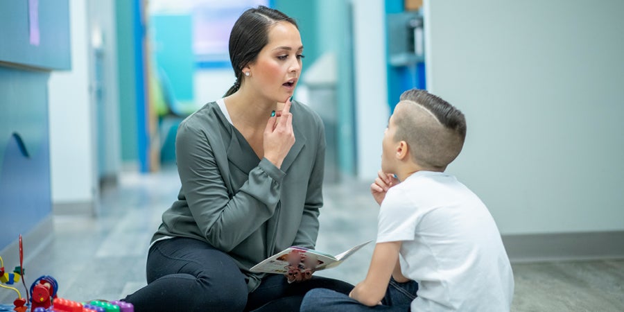 teacher working with special ed student on speech pathology