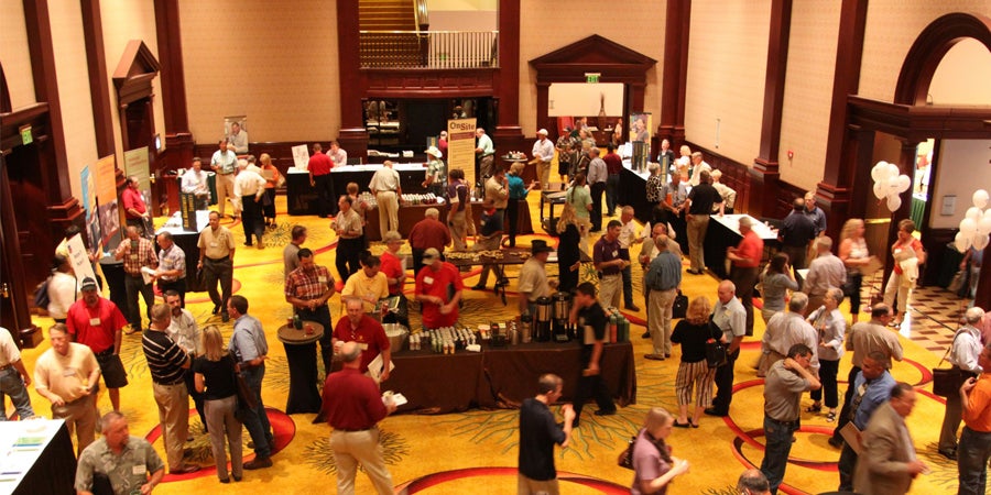 photo of a summer leadership institute conference room filled with people conversing with each other