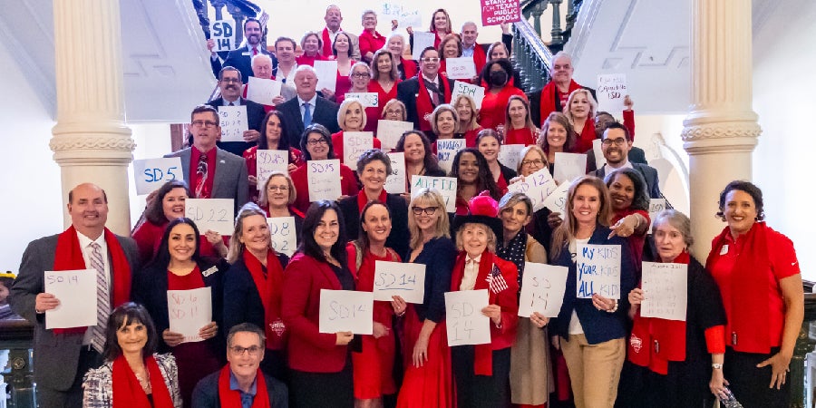 LAC Trustees holding up signs inside state Capitol building
