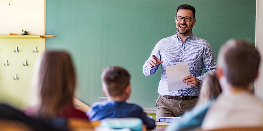 Teacher speaking to elementary students in classroom